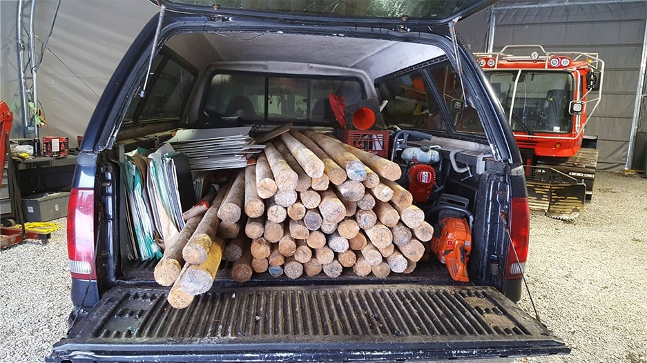 Pickup truck bed loaded with sign posts and trail maintenance supplies