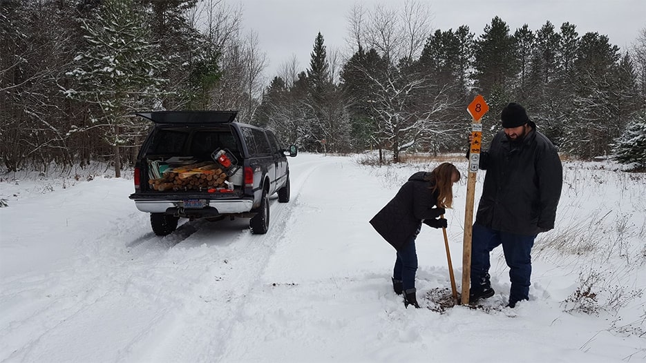 Two SORVA members putting in a new sign in the winter