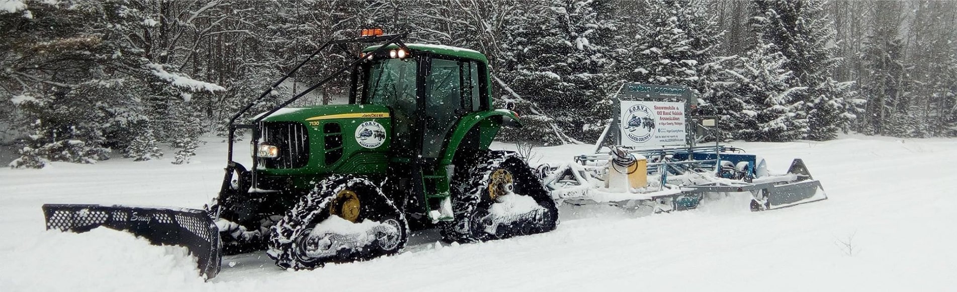 Deere tractor in the snow with groomer